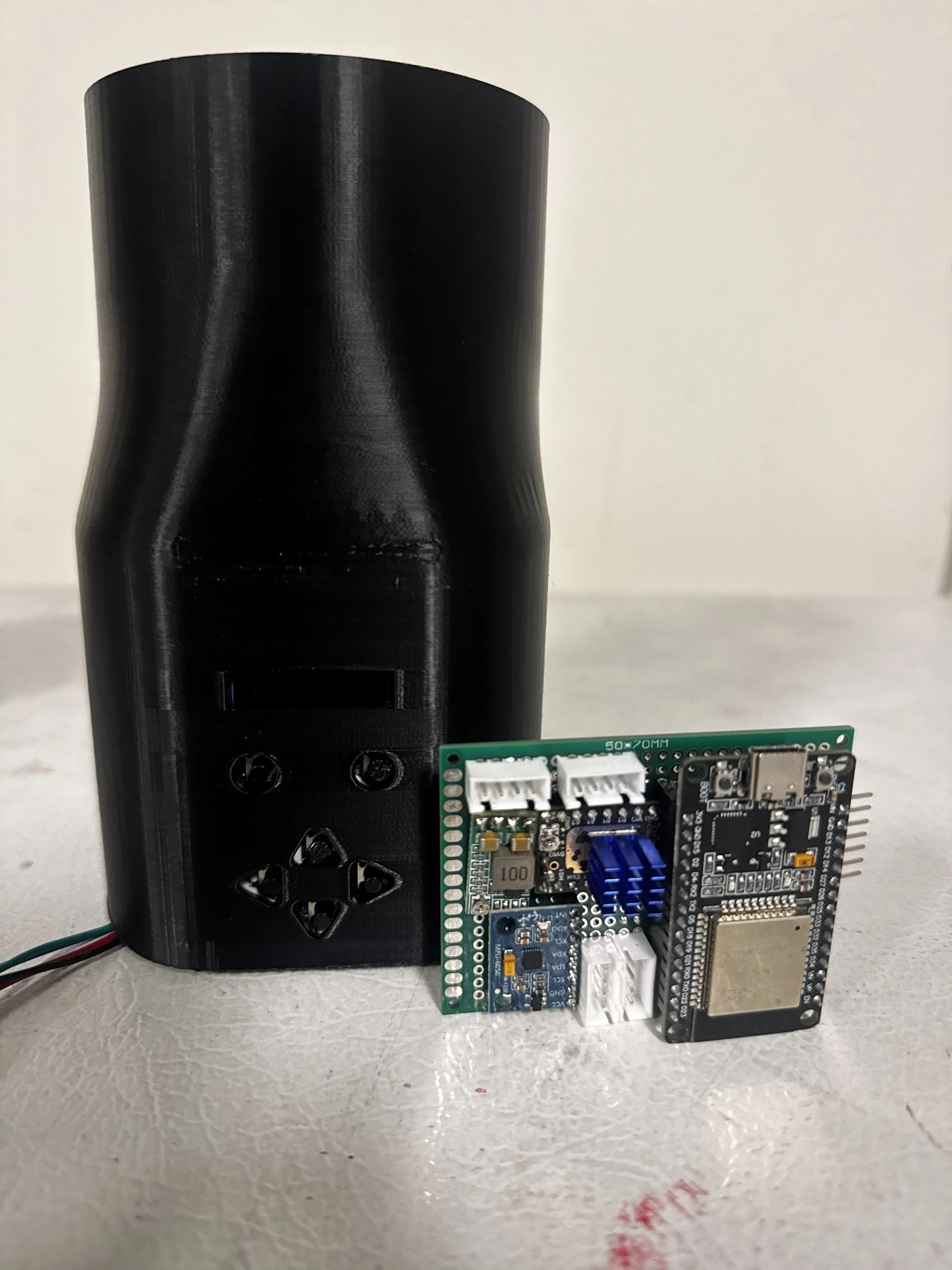 V1 — the single-axis equatorial mount: a tall 3D-printed housing with an early D-pad controller cut-out, beside the first prototype control board.